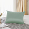 Housse de couette en soie mulberry vert sauge naturel posée sur un tissu gris texturé.