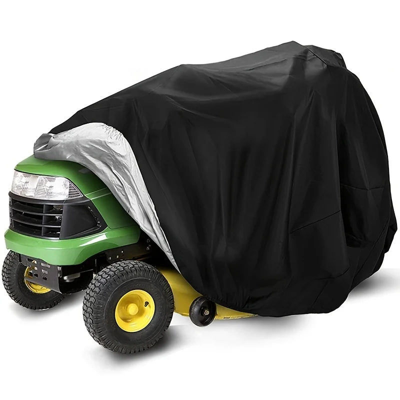 A green heavy-duty yard tractor is covered with a black waterproof tarp, revealing a silver protective layer.