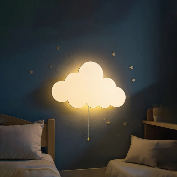 Una luz nocturna de nube blanca brillante montada en una pared azul oscuro sobre una cama.