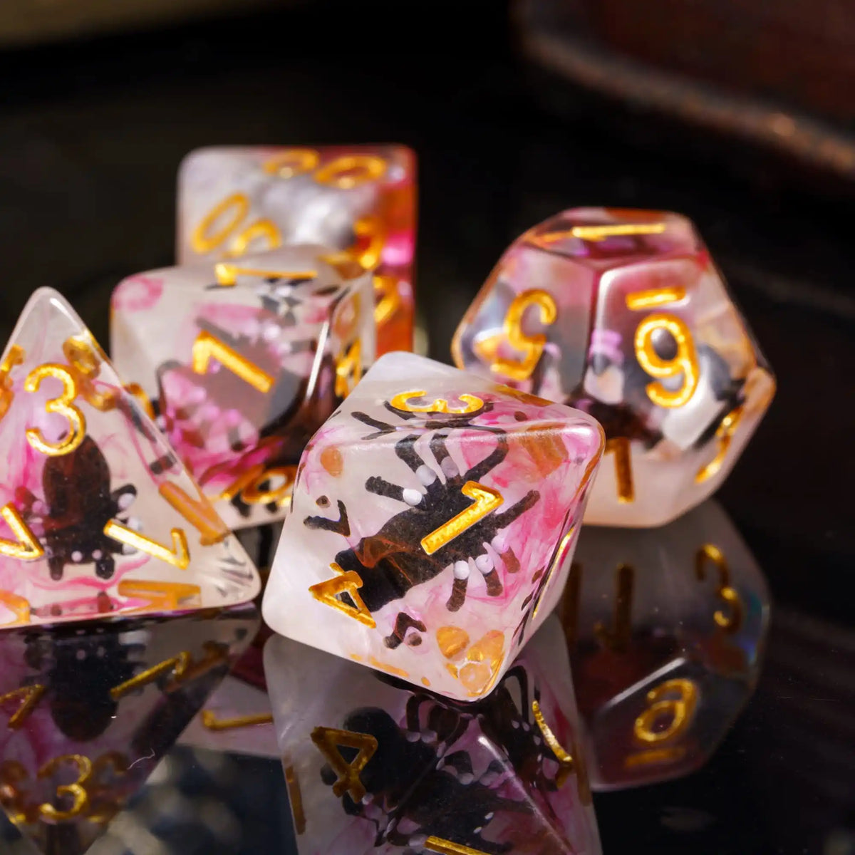 A close-up of a set of colorful resin dice featuring animal designs and glitter in various shapes and colors.
