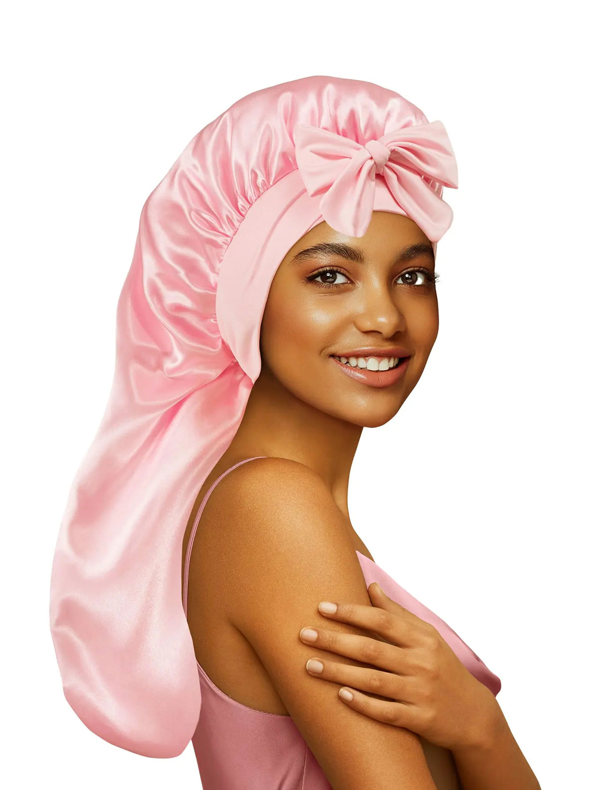 A woman wearing a pink satin sleep bonnet tied in a bow, shown from the side.