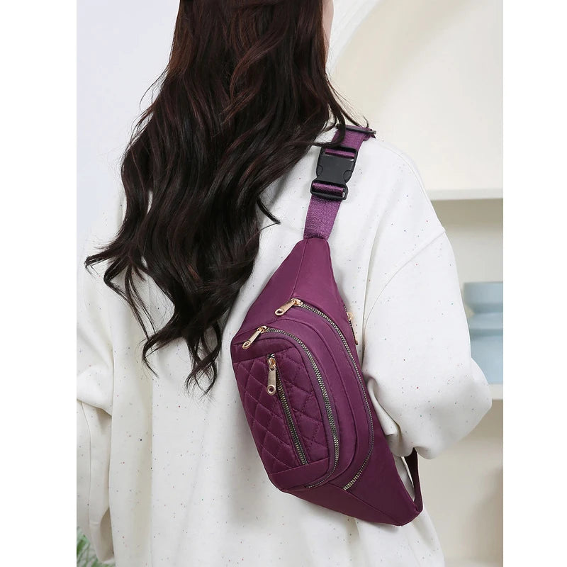 Un sac banane en nylon violet porté par une femme aux longs cheveux noirs, vu de dos.