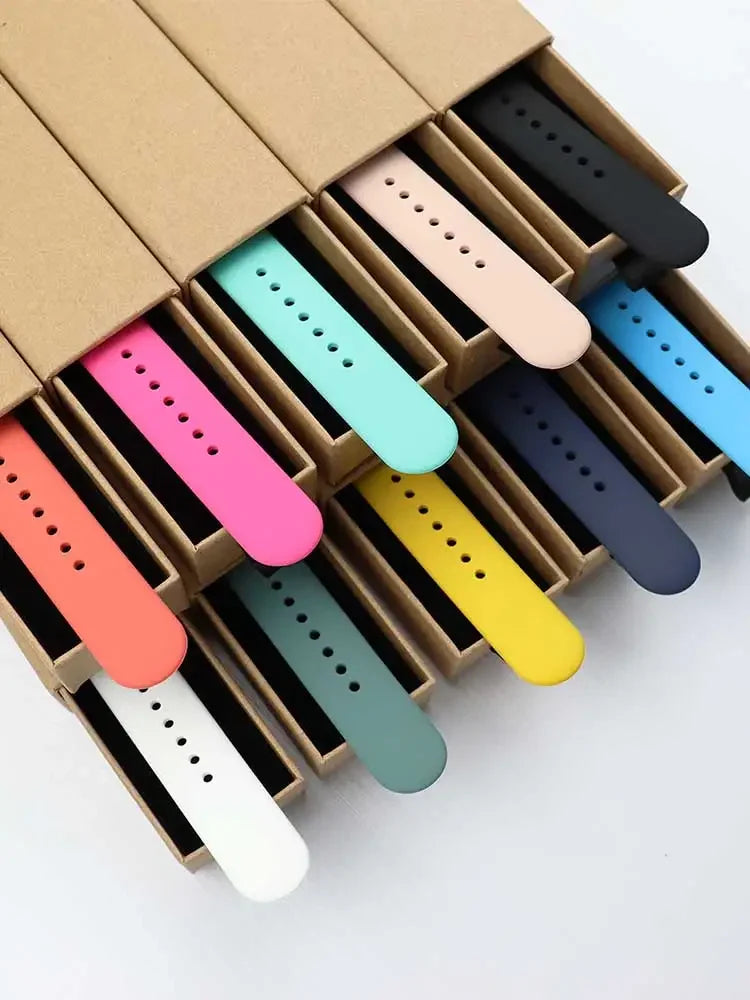 A box filled with various colored soft silicone sport bands for an Apple Watch.