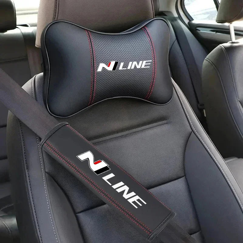 A black PU leather car headrest pillow and seatbelt shoulder pad set installed in a car seat.