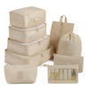 A set of beige travel packing cubes and storage organizer bags stacked and laid out.