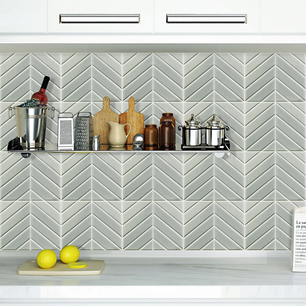 A kitchen display featuring a shelf with various ceramic and metal kitchenware against a white herringbone tile backsplash.