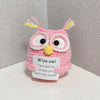 A handmade crochet owl doll with pink and yellow accents, featuring large eyes and yellow tufts.