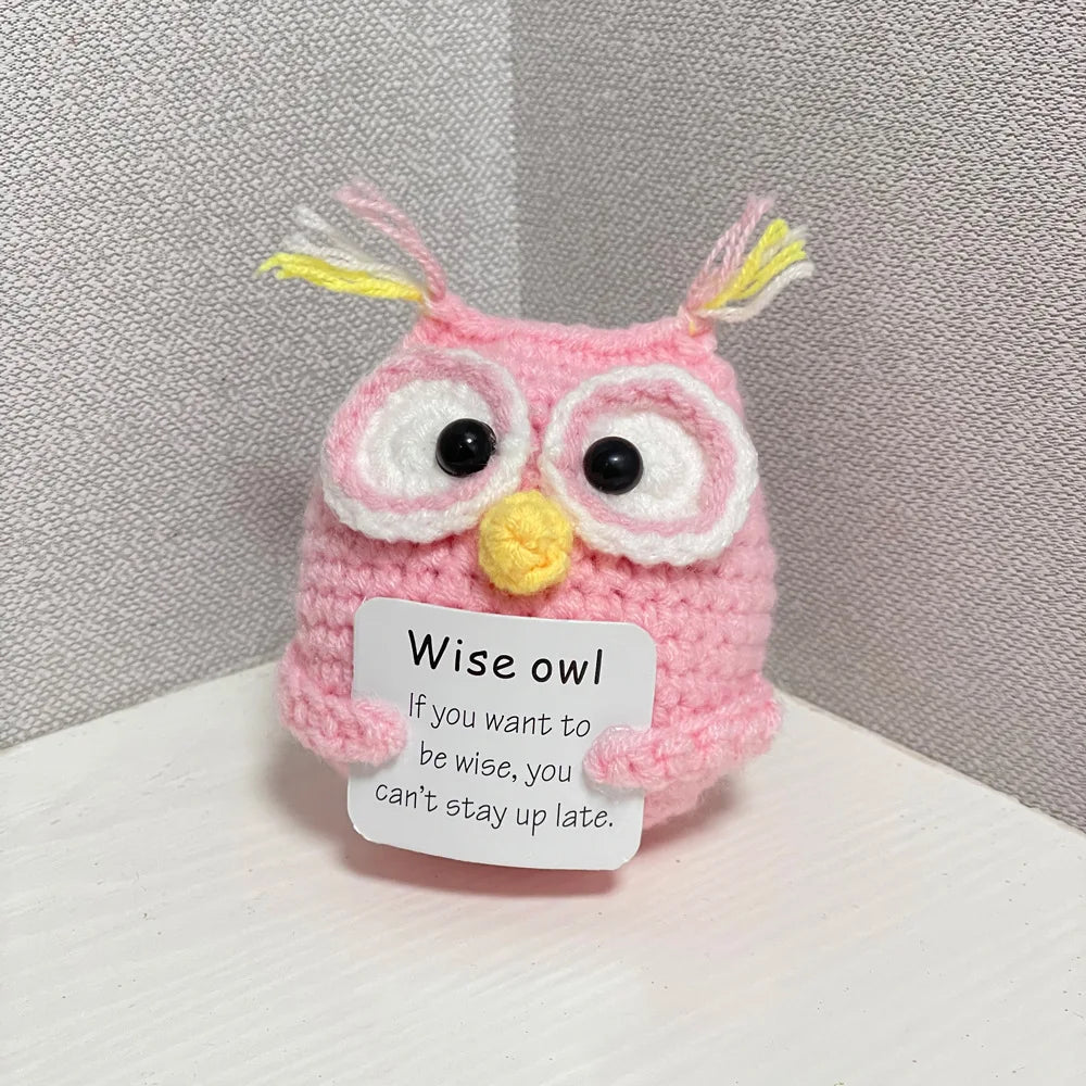 A handmade crochet owl doll with pink and yellow accents, featuring large eyes and yellow tufts.