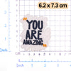 White embroidered patch with black text YOU ARE AMAZING and small orange accents