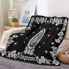 Black tapestry featuring a white floral design and the word Supreme on a sofa throw.