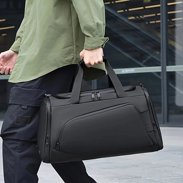 Una persona lleva un bolso de viaje negro para hombre con compartimento para zapatos en un entorno al aire libre.