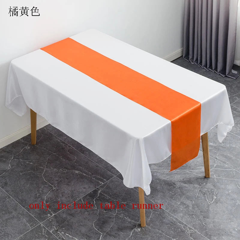 White tablecloth with an orange satin table runner displayed on a table.