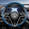 Close-up view of a black steering wheel with blue carbon fiber texture covers and a Mercedes-Benz emblem.