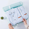 A light blue travel packing cubes set with a zippered storage organizer bag is being held by hands.