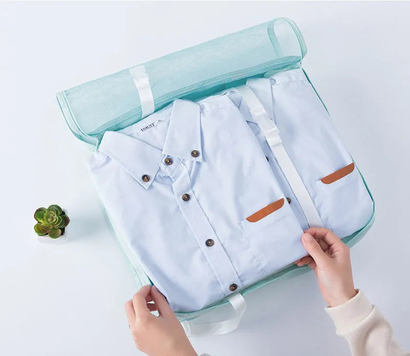 A light blue travel packing cubes set with a zippered storage organizer bag is being held by hands.