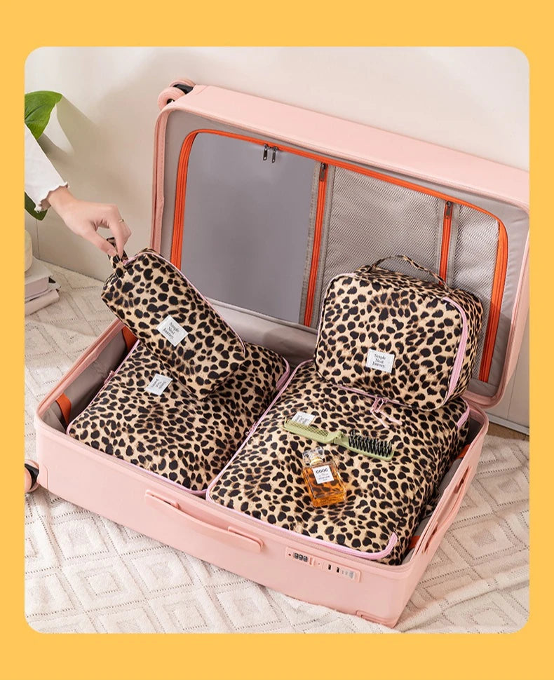 A pink toiletry box is open, revealing a leopard print storage bag filled with toiletries.
