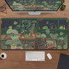 A large desk mat featuring a nature design of various green frogs and potted plants.