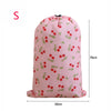 Pink drawstring laundry bag with a pattern of red and green berries
