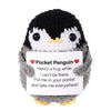Handmade knitted penguin doll with a card featuring a message about being put in a pocket