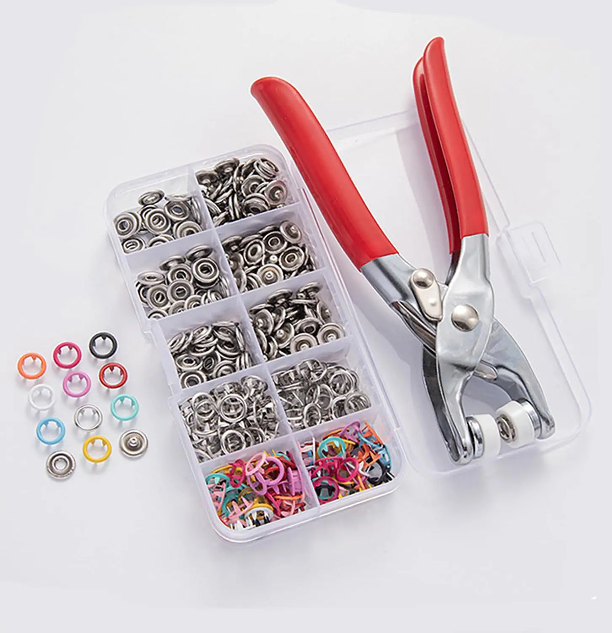 A clear plastic case holds a set of pliers and various snap fasteners for use in crafting or repair.