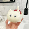 A hand holds a white cat-shaped soap box with a red drainage tray against a white tiled background.
