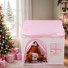A pink floral playhouse tent for kids with a rounded archway and a window, decorated with festive greenery.