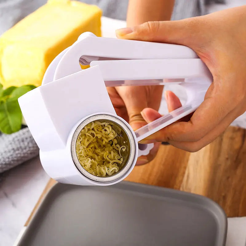 Une main utilise une râpe à fromage manuelle rotative pour râper du fromage.