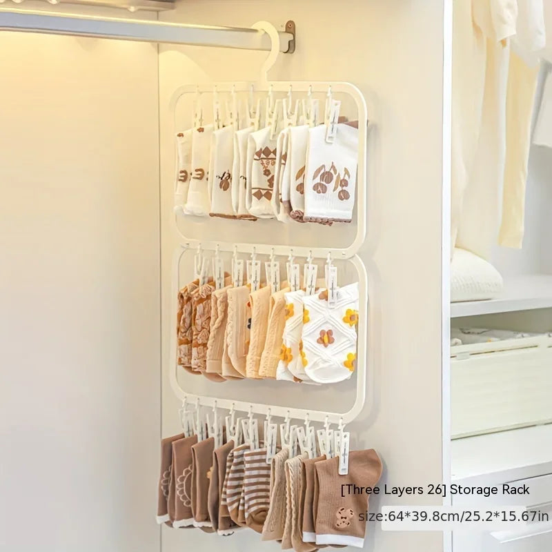 A white storage rack with multiple hanging clips for laundry drying, showing various fabric items.