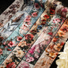 Rolls of vintage botanical washi tape featuring floral designs in pink, red, and muted tones for scrapbooking.