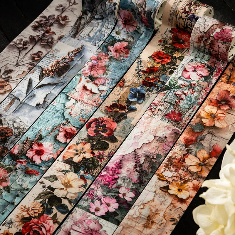 Rolls of vintage botanical washi tape featuring floral designs in pink, red, and muted tones for scrapbooking.