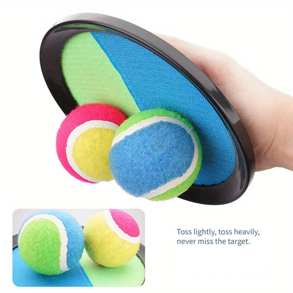 A hand holds a black foam dartboard with colorful felt balls, demonstrating the toss ability of the sticky catch ball set.