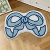 A light blue, bow-shaped absorbent non-slip doormat with a fluffy texture placed on a wooden floor.