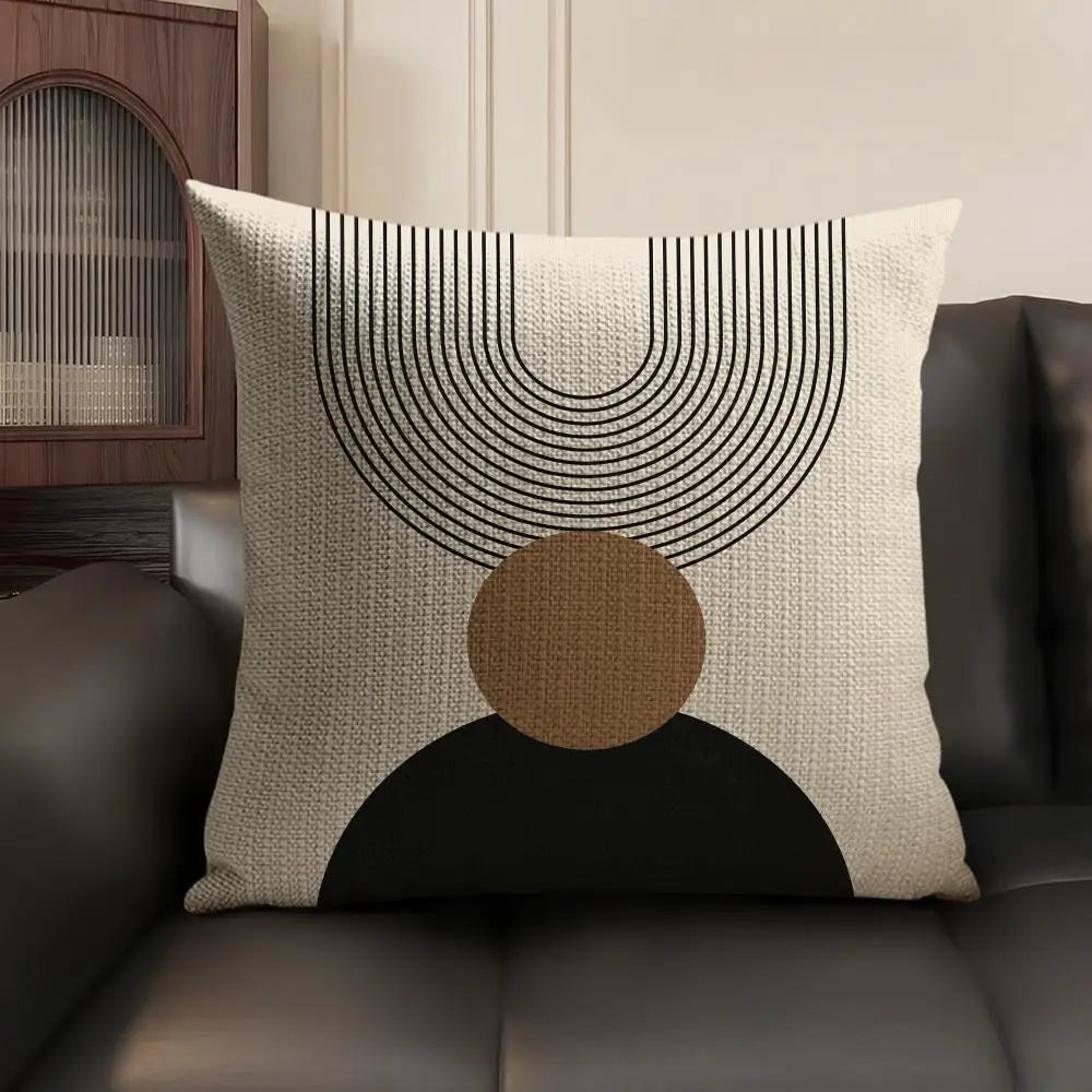 A beige linen cushion cover featuring a geometric design of concentric black lines and a large circular brown shape on a dark