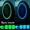 A set of eight mixed glow-in-the-dark tire valve caps in various shades of green and blue.