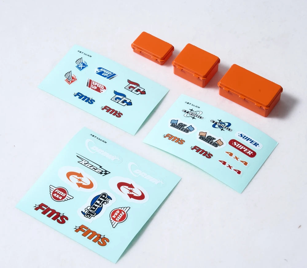 A set of orange RC car decorative accessories including surfboard, kayak, and roadblocks.