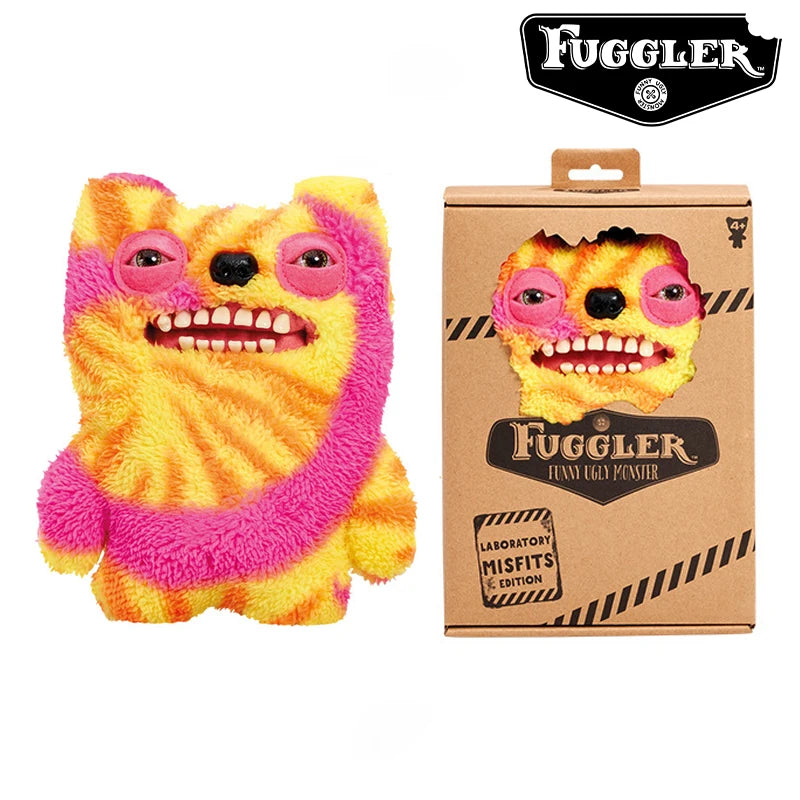 A bright orange and yellow plush toy resembling an ugly monster with pink accents, packaged in a brown box.
