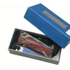 A compact folding knife with a red handle and silver blade is displayed in its blue presentation box.