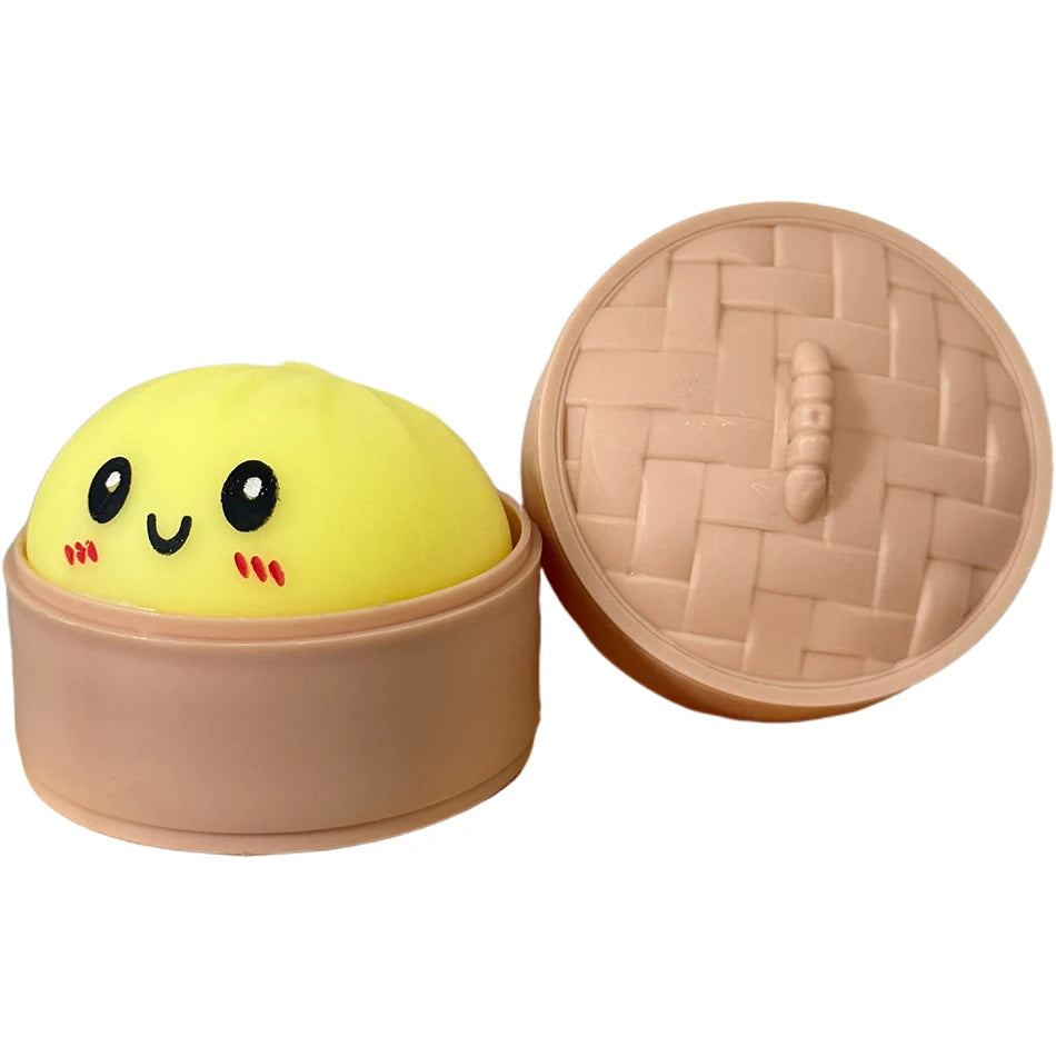 Pinkes Silikon-Sensorspielzeug in Form eines Dumplings mit Deckel und einem gelben Quietschgesicht.