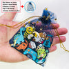 A hand holds a clear pouch filled with colorful PVC charms and pins for shoe decoration.