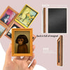A hand holds a framed picture of a 3D monkey with dark hair, showing the front and back details.