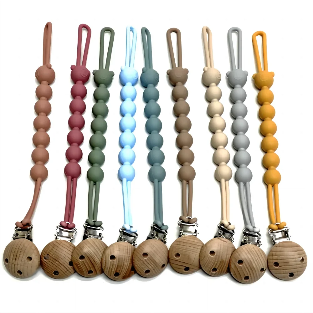 A set of food-grade silicone pacifier clips with anti-lost chains in various pastel colors.