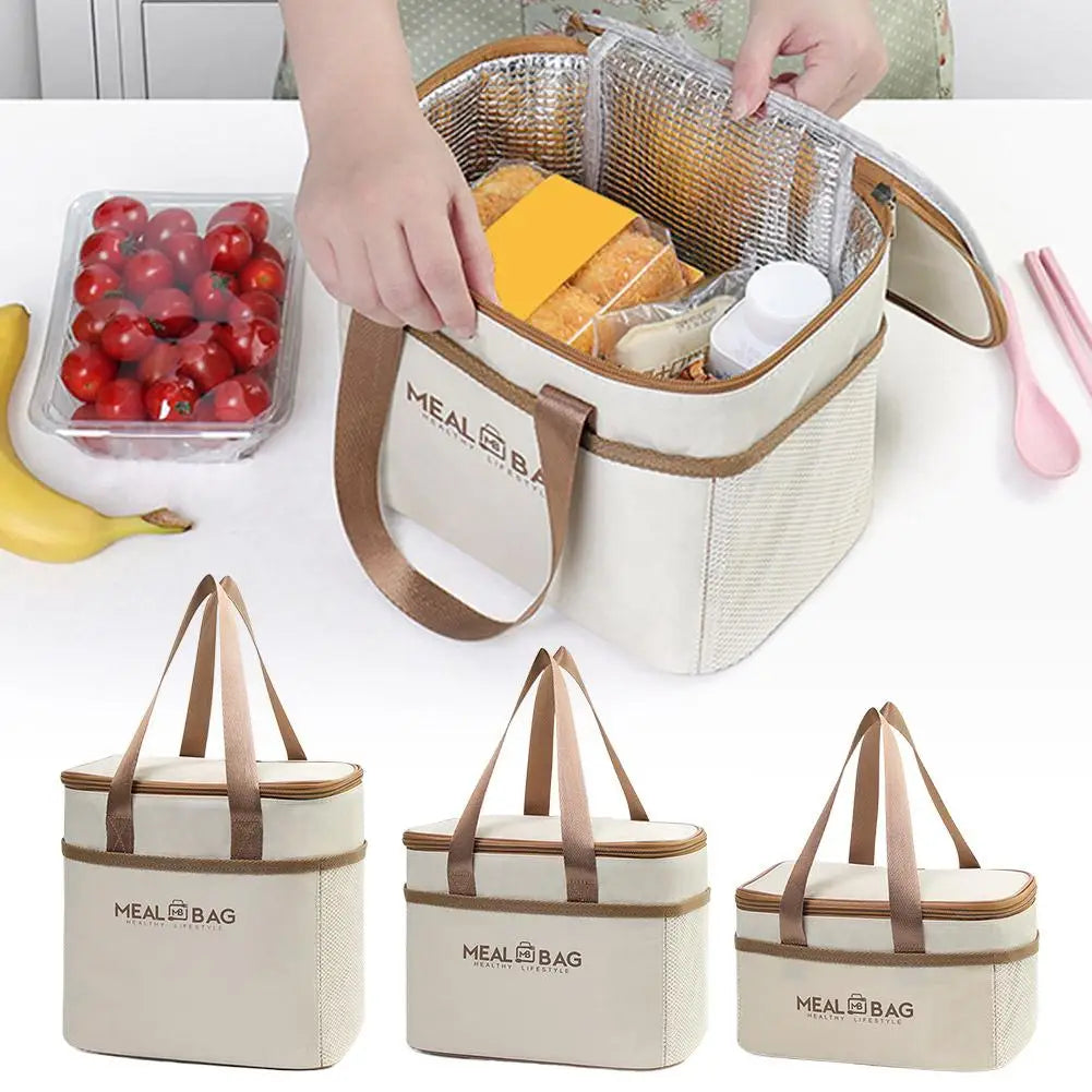 A beige insulated lunch bag is shown open, revealing a clear mesh compartment filled with baked goods and a white container.