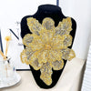 A large, intricate gold sequin floral lace applique patch for sewing and DIY crafts displayed on a black mannequin.
