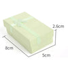 A rectangular light green velvet jewelry gift box tied with a pale green ribbon.