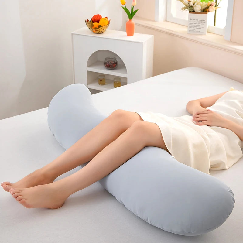 Una persona acostada sobre una superficie blanca con una almohada ergonómica de lado curva azul claro.