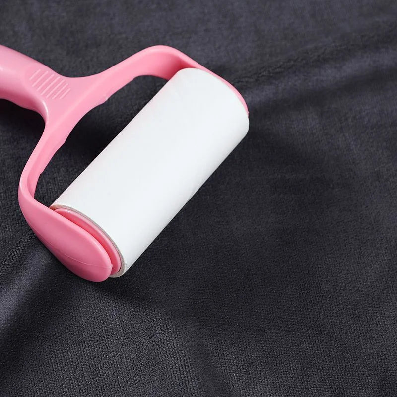 A pink towel holder with a white microfiber bath towel rolled inside, placed on a dark gray fabric.