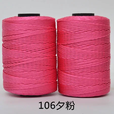 Two spools of bright pink 3-ply polyester knitting yarn for crochet and hand crafts