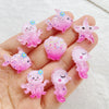 Pink and purple resin sea creature charms shaped like starfish, jellyfish, and small fish held in a hand.