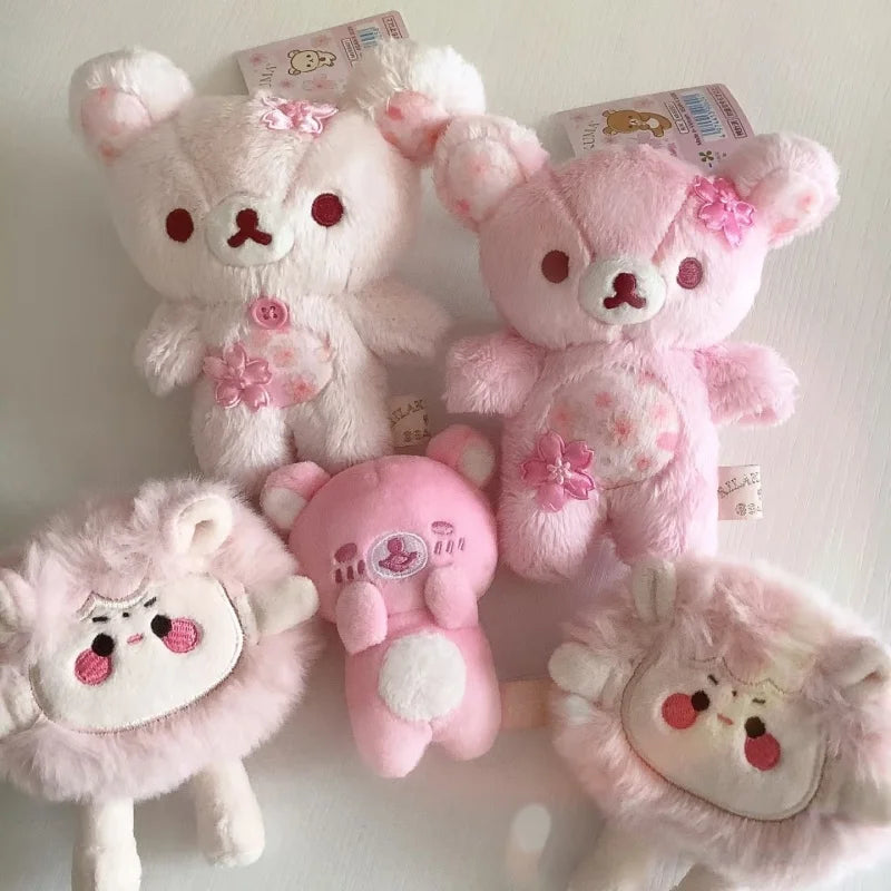 A collection of pink and white cherry blossom plush bear keychains.