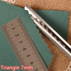 A pair of silver triangle pinking shears resting on a green felt and a ruler.
